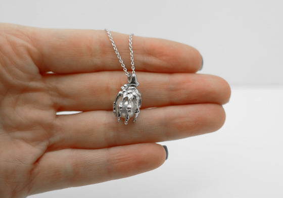 Skeleton hand pendant with white pearl